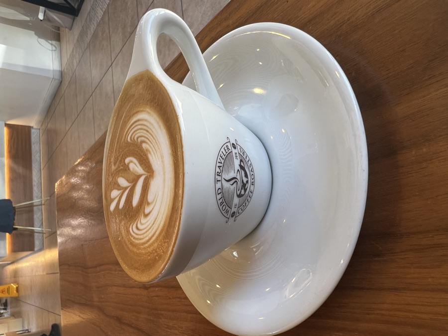 Latte with leaf art in a World Traveler Coffee Roasters cup