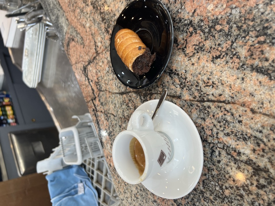 Espresso and a pastry on a granite counter