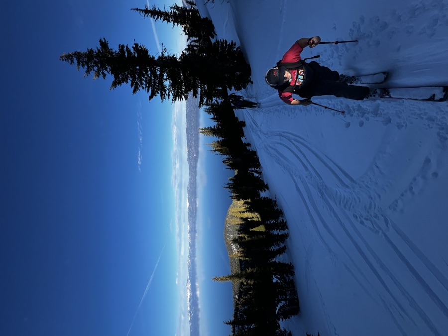 Skinning up a track with Lake Tahoe far below under a deep blue sky