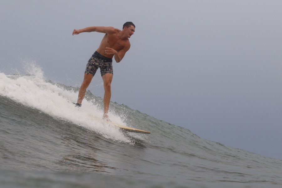 Cross-stepping toward the nose of a longboard down the face of a wave