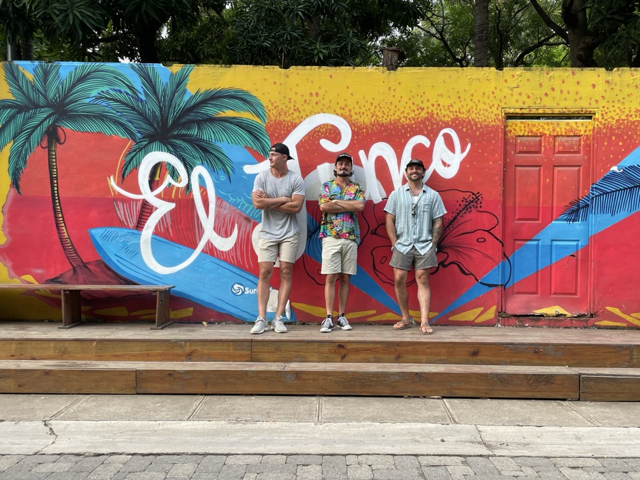 In front of a colorful El Tunco surf mural in El Salvador